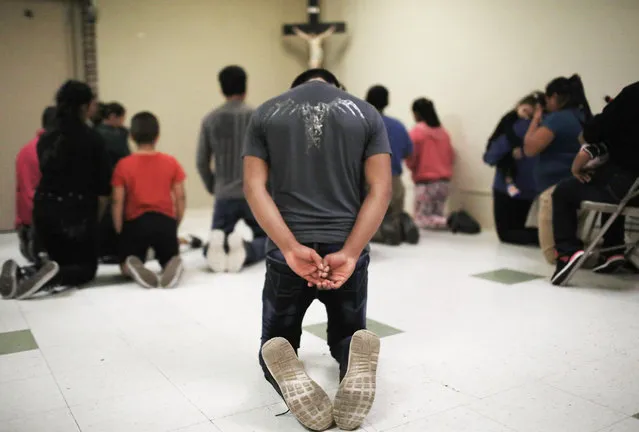 Migrants pray at an Annunciation House shelter for migrants on October 13, 2018 in El Paso, Texas. Annuciation House said it is currently receiving over 700 migrants, all families, released from ICE holding cells per week. (Photo by Mario Tama/Getty Images)