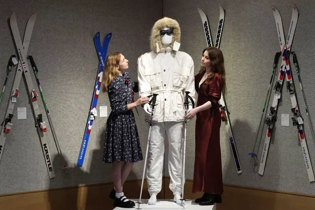 Bonhams employees stand with Sir Roger Moore's white ski suit from A View to a Kill, which has an estimate of £15,000 - 25,000, part of the “Sir Roger Moore: The Personal Collection” sale, at Bonhams auction rooms in London, Monday, October 2, 2023. (Photo by Kirsty Wigglesworth/AP Photo)