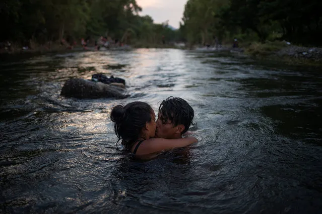 Israel and Estelle, both from Honduras, part of a caravan of thousands of migrants from Central America en route to the United States, kiss while bathing in Rio Novillero in San Pedro Tapanatepec, Mexico October 27, 2018. (Photo by Adrees Latif/Reuters)