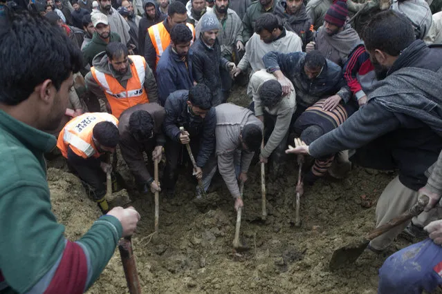 Kashmiri villagers and officials search for bodies following landslides due to heavy rainfall in the village of Laden some 45 Kilometers (28 miles) west of Srinagar, Indian-controlled Kashmir, Monday, March 30, 2015. (Photo by Dar Yasin/AP Photo)