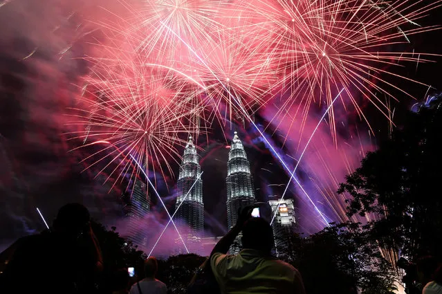 Fireworks illuminate the sky near Malaysia' s landmark Petronas Twin Towers during the New Year celebrations in Kuala Lumpur on January 1, 2017. (Photo by Mohd Rasfan/AFP Photo)