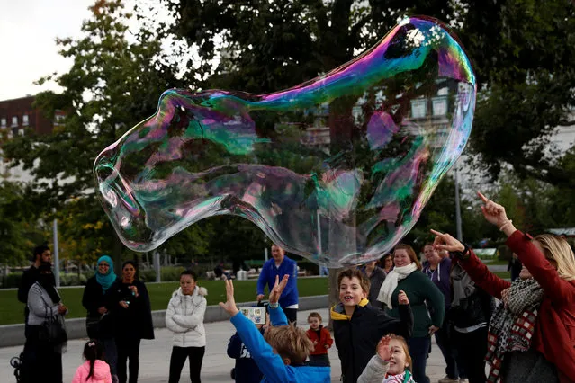 People chase a giant soap bubble in central London, Britain October 10, 2016. (Photo by Stefan Wermuth/Reuters)