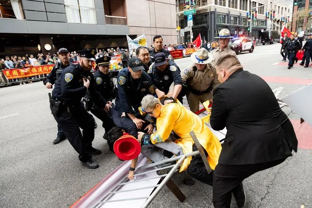 Police try to detain a man after skirmishes between anti-Chinese Communist Party protesters and pro-China protesters near the Asia-Pacific Economic Cooperation (APEC) summit in San Francisco, on November 16, 2023. The APEC Summit takes place through November 17. (Photo by Jason Henry/AFP Photo)