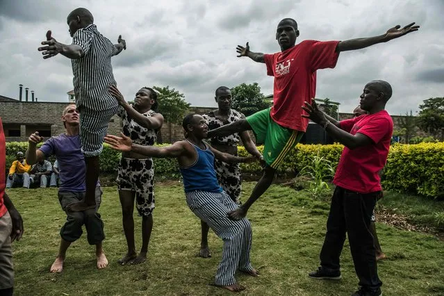 Prisoners try some acrobatic figures during a workshop with the Sarakasi circus performers at Kamiti prison, Nairobi February 11, 2016. Sarakasi Circus performes dance, acrobatics and workshops for the inmates at Kamiti maximum security prison in order provide another form of engagement during their incarceration. (Photo by Fredrik Lerneryd/AFP Photo)