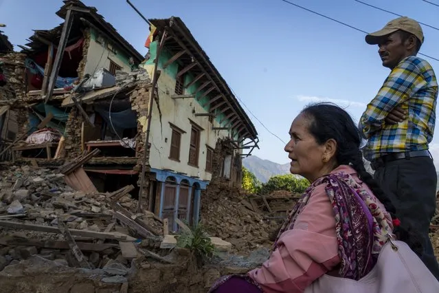 A woman sits in front of her earthquake damaged house in Jajarkot district, northwestern Nepal, Sunday, November 5, 2023. (Photo by Niranjan Shrestha/AP Photo)