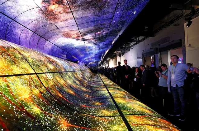Attendees watch a display made up of curved OLED television screens at the LG Electronics booth during the 2019 CES in Las Vegas, Nevada, U.S. January 8, 2019. (Photo by Steve Marcus/Reuters)