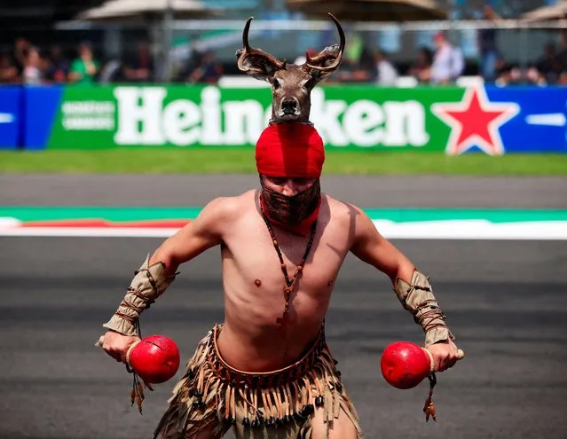An artist performs before the start of the Formula One Mexico Grand Prix at the Hermanos Rodriguez racetrack in Mexico City on October 30, 2022. (Photo by Carlos Perez Gallardo/Pool via AFP Photo)