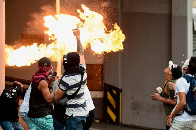 Opposition demonstrators clash with security forces in a protest against the government of President Nicolas Maduro on the anniversary of the 1958 uprising that overthrew the military dictatorship, in Caracas on January 23, 2019. Venezuela's National Assembly head Juan Guaido declared himself the country's “acting president” on Wednesday during a mass opposition rally against leader Nicolas Maduro. (Photo by Federico Parra/AFP Photo)