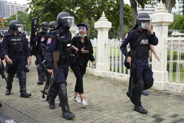 Riot police detain an anti-government protester during protest in Bangkok, Thailand, Wednesday, Aug. 11, 2021. Protesters demanded the resignation of Prime Minister Prayuth Chan-ocha for what they say is his failure in handling the COVID-19 pandemic. (Photo by Sakchai Lalit/AP Photo)