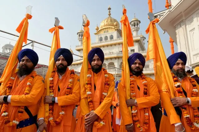 Sikh holy men known as “Panj Pyare” carry a religious flags during a procession on the eve of Guru Teg Bahadur's martyrdom day, at the Golden Temple in Amritsar on December 16, 2023. (Photo by Narinder Nanu/AFP Photo)