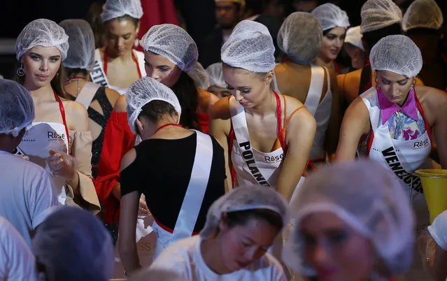 Miss Universe contestants, from left facing camera; Yuliana Korolkova of Russia, Alena Spodynyuk of Ukraine, Izabella Krzan of Poland and Mariam Habach of Venezuela help in packing meals for distribution to the needy in suburban Pasay city southeast of Manila, Philippines Wednesday, January 18, 2017. (Photo by Bullit Marquez/AP Photo)