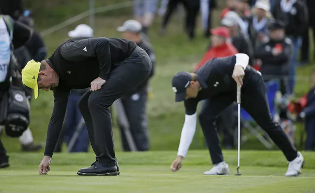 Wayne Gretzky, left, and Jordan Spieth, right, repair their marks on the 17th green of the Spyglass Hill Golf Course during the second round of the AT&T Pebble Beach Pro-Am golf tournament Friday, February 8, 2019, in Pebble Beach, Calif. (Photo by Eric Risberg/AP Photo)