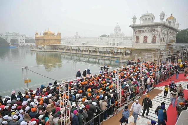 Devotees gather to pay their respects at the Golden Temple on the New Year's Day in Amritsar on January 1, 2024. (Photo by Narinder Nanu/AFP Photo)