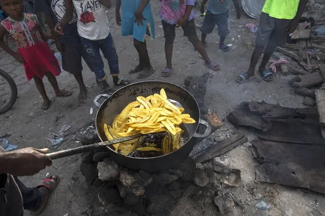 A vendor fries a batch of plantains at a market in the La Saline neighborhood near the main port entrance, partially burned by a gang two years ago, in Port-au-Prince, Haiti, Monday, September 13, 2021. (Photo by Rodrigo Abd/AP Photo)