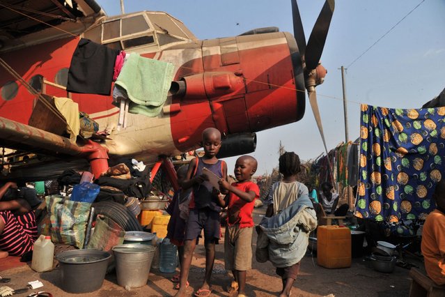 Children stand next to a plane in the camp for displaced persons at the Mpoko airport in Bangui, on January 21, 2014, a day after the election of Catherine Samba-Panza as the new President of the Central African Republic. The European Union agreed on January 20 to send hundreds of troops to the Central African Republic in a rare joint military mission aimed at ending months of sectarian violence. (Photo by Issouf Sanogo/AFP Photo)