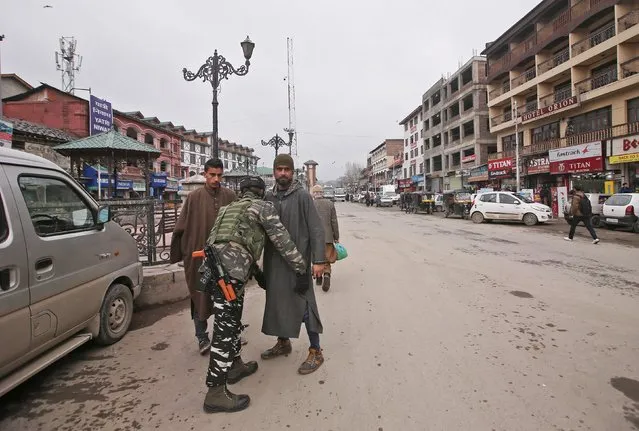 An Indian Central Reserve Police Force (CRPF) personnel frisks a man at a street in Srinagar, February 18, 2019. (Photo by Danish Ismail/Reuters)