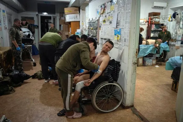 Military medics give first aid to wounded Ukrainian soldiers at a medical stabilisation point near Bakhmut in Donetsk region, Ukraine on January 26, 2024. (Photo by Efrem Lukatsky/AP Photo)