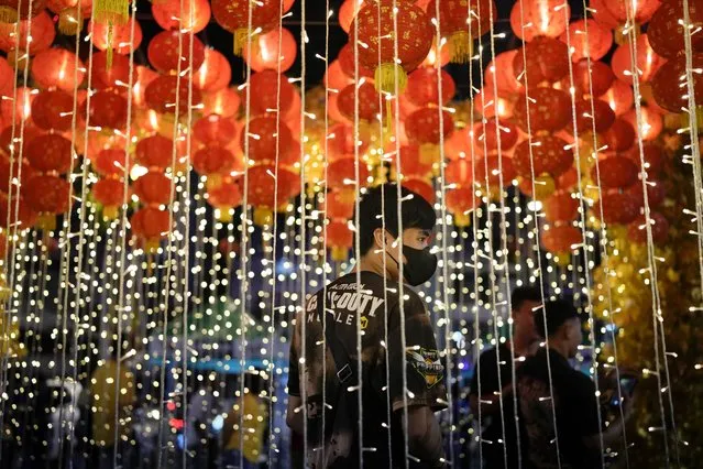 A man stands under lanterns during an event for the 430th anniversary of Manila's Chinatown, said to be the oldest in the world, at the capital's Binondo district, Philippines on Thursday, February 1, 2024. Crowds are flocking to Manila's Chinatown to usher in the Year of the Wood Dragon and experience lively traditional dances on lantern-lit streets with food, lucky charms and prayers for good fortune. (Photo by Aaron Favila/AP Photo)