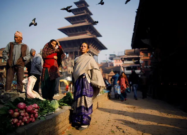 People gather to bask in the sun at a market during the early morning hours in Bhaktapur, Nepal January 10, 2017. (Photo by Navesh Chitrakar/Reuters)