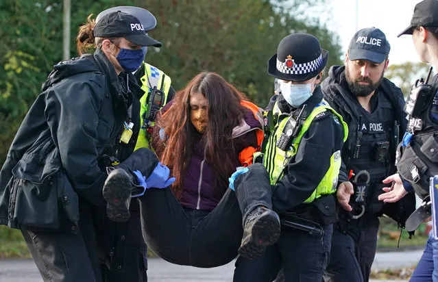 Protesters from Insulate Britain are removed by police after they blocked a road near to the Holiday Inn Express Motorway Airport in Manchester on Tuesday, November 2, 2021. (Photo by Peter Byrne/PA Images via Getty Images)