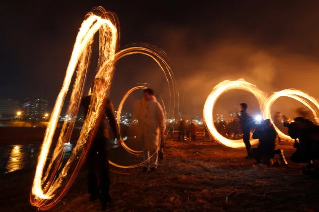 South Koreans spin “Jwibullori” fireballs during the traditional festivities of the first full moon two day ahead of the lunar year, in Seoul, South Korea, 17 February 2019. Daeboreum, the first full moon of the lunar calendar, is one of the biggest traditional holidays in Korea. The traditional “Jwibullori” is a custom where people swing burners full of coals in rice paddies to chase away evil spirits and bad luck. (Photo by Jeon Heon-Kyun/EPA/EFE)