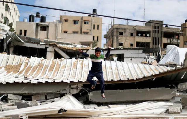 A Palestinian boy jumps at the destroyed Hamas site following Israeli air strikes, in Gaza City March 15, 2019. (Photo by Mohammed Salem/Reuters)
