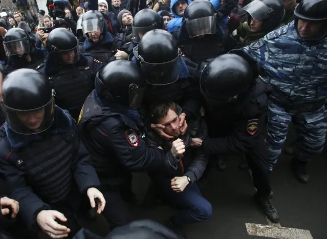 Russian police officers detain an opposition activist outside a court room in Moscow, Russia, Monday, February 24, 2014, where hearings started against opposition activists detained on May 6, 2012 during a rally at Bolotnaya Square. (Photo by Denis Tyrin/AP Photo)
