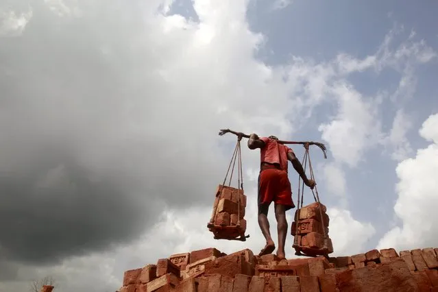 A labourer carries bricks at a brick factory on the eve of May Day or Labour Day on the outskirts of Agartala, India, April 30, 2015. (Photo by Jayanta Dey/Reuters)