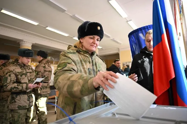 A service member casts her ballot in Russia's presidential election in Moscow on March 15, 2024. (Photo by Natalia Kolesnikova/AFP Photo)