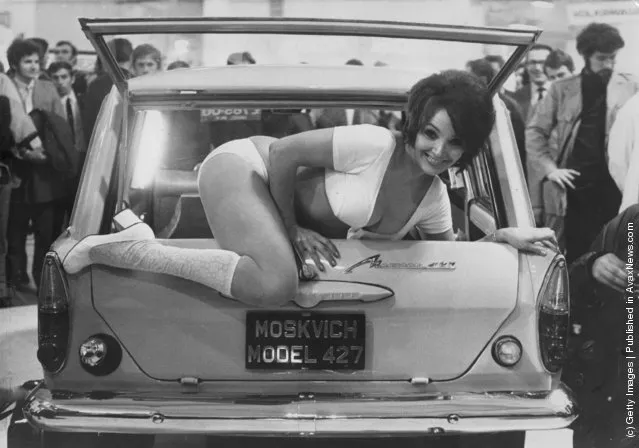 1971: Julie Desmond, a scantily clad, 24 year old model, climbs out of the back of a Russian Moskvich 427 car, at a car trade show