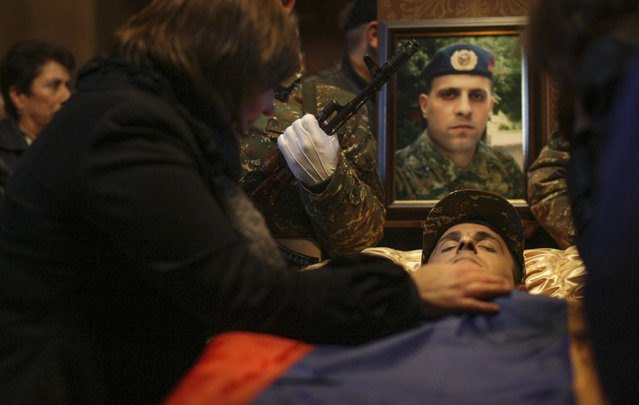 A relative mourns during a farewell ceremony for Pvt. Sasun Mkrtchyan, Armenian serviceman who was killed during fighting in the separatist region of Nagorno-Karabakh, in Yerevan, Armenia, Monday, April 4, 2016.  Fighting raged Monday around the separatist region of Nagorno-Karabakh, with Azerbaijan saying three of its troops have been killed in the past 24 hours and the Armenian president warning that the hostilities could slide into a full-scale war. (Varo Rafayelyan/ PAN Photo via AP)