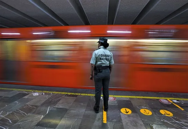 A member of the Mexican National Guard stands guard at a city's subway station in Mexico City,bThursday, January 12, 2023. The mayor of Mexico City says that more the 6 thousand National Guard officers will be posted in the city's subway system after a series of accidents that officials say could be due to sabotage. (Photo by Fernando Llano/AP Photo)
