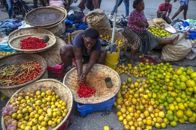 A street vendor prepares her produce for sale in Port-au-Prince, Haiti, Sunday, October 17, 2021. (Photo by Joseph Odelyn/AP Photo)