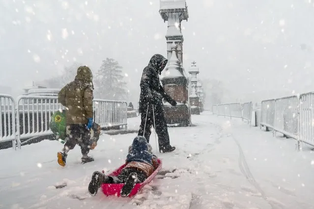 A kid is pulled on a sled as a winter storm delivers heavy snow to the Capitol in Washington, Monday, January 3, 2022. (Photo by J. Scott Applewhite/AP Photo)