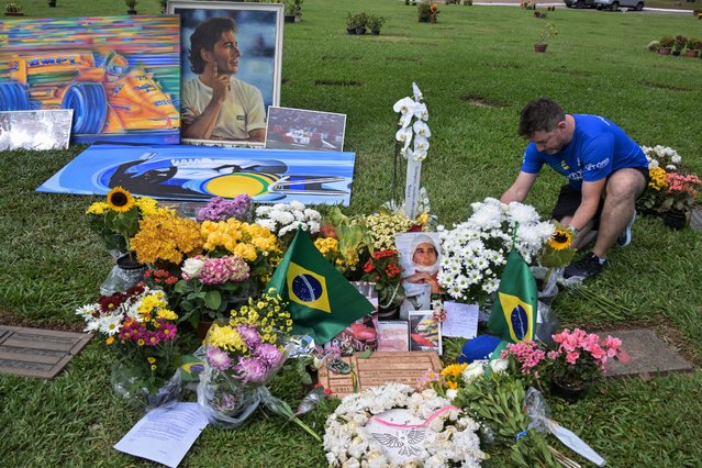 A man visits the grave of Brazilian F1 driver Ayrton Senna in Sao Paulo, Brazil, on May 1, 2024, during the 30th anniversary of his death. Thirty years after his death at the San Marino Grand Prix, Ayrton Senna is still adored in Formula One, a sport his fatal accident reshaped. The 34-year-old Brazilian was leading at Imola on May 1, 1994, when he went off the track at the Tamburello curve and smashed into a concrete wall. (Photo by Nelson Almeida/AFP Photo)