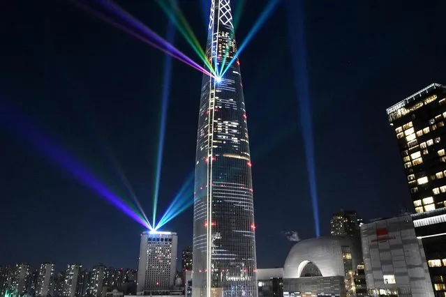 Beam lights are projected from the 123-storey Lotte World Tower skyscraper during a countdown lighting show to celebrate the New Year in Seoul on January 1, 2022. (Photo by Jung Yeon-je/AFP Photo)