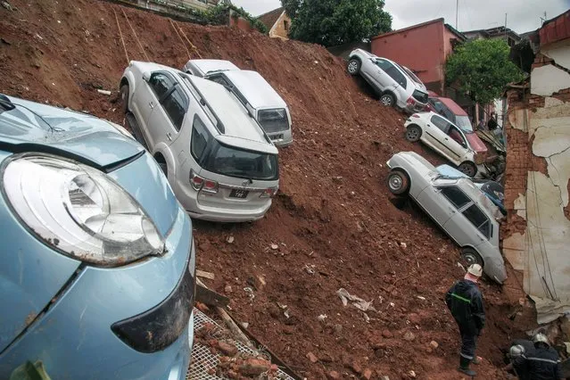 A general view of a car park housing several private cars collapsed on houses following the heavy rains of the last few days in the Ankadifotsy neighbourhood of Antananarivo on January 24, 2022. Rescuers recovered five bodies (four children and one adult) from the rubble and are still looking for two missing people who were startled by the landslide in their sleep. Antananarivo and several regions of Madagascar have been hit by strong tropical storms that have caused 34 deaths and more than 62,000 people affected, according to the authorities. (Photo by Rijasolo/AFP Photo)