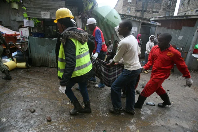 Rescue team members carry the body of an unidentified man from the rubble of a six-storey building that collapsed after days of heavy rain, in Nairobi, Kenya April 30, 2016. (Photo by Gregory Olando/Reuters)