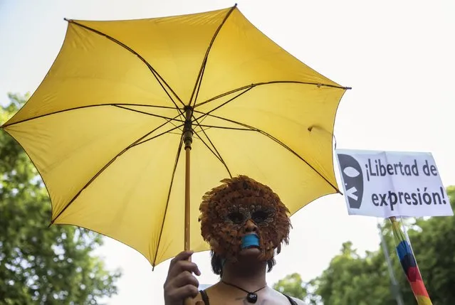 A woman, with her mouth taped, wears a mask during a protest against Spanish government's new security law in central Madrid, Spain, June 30, 2015. Spanish government's new security law, which toughens fines for unauthorised street protests, comes into effect July 1. Critics consider it a violation of the right to protest and a limit to free expression and have labelled it “Ley Mordaza” (Gag Law). The banner reads: “Freedom of expression”. (Photo by Sergio Perez/Reuters)