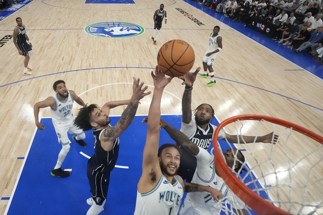 Minnesota Timberwolves forward Kyle Anderson (1) reaches for a rebound against Dallas Mavericks center Dereck Lively II, left, and forward Derrick Jones Jr., back, right, during the first half of Game 1 of the NBA basketball Western Conference finals Wednesday, May 22, 2024, in Minneapolis. (Photo by Abbie Parr/AP Photo)