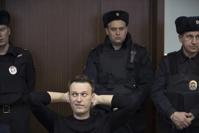 Russian opposition leader Alexei Navalny, foreground left, waits to hear a sentence in court in Moscow, Russia, Thursday, March 30, 2017. Many Western countries have condemned the arrests and called for the release of those sentenced to jail, including opposition leader Alexei Navalny, Putin's most prominent foe. (Photo by Pavel Golovkin/AP Photo)