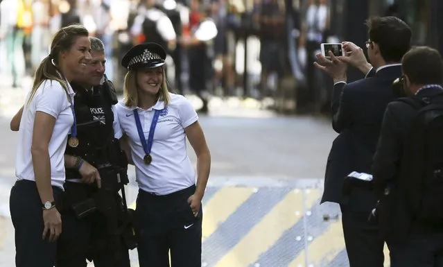 Members of the England women's football team pose for a photograph with a police officer in  Downing Street, London, Britain July 9, 2015. (Photo by Paul Hackett/Reuters)