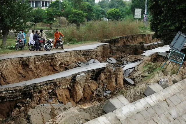 People on bikes gather near a damaged road after an earthquake in Mirpur, Pakistan, September 25, 2019. The death toll from an earthquake that struck Pakistani Kashmir jumped to 37, officials said on Wednesday, as families mourned relatives and rescue teams sent supplies to the area. (Photo by Akhtar Soomro/Reuters)
