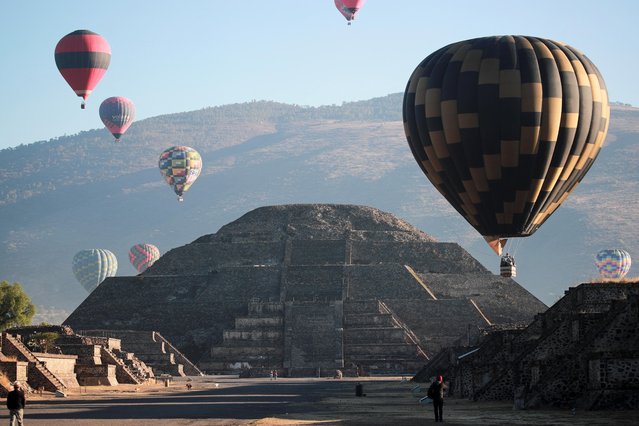 Hot air balloons float above the Pyramid of the Moon on the day of the spring equinox in the pre-hispanic city of Teotihuacan, on the outskirts of Mexico City, Mexico on March 20, 2023. (Photo by Henry Romero/Reuters)