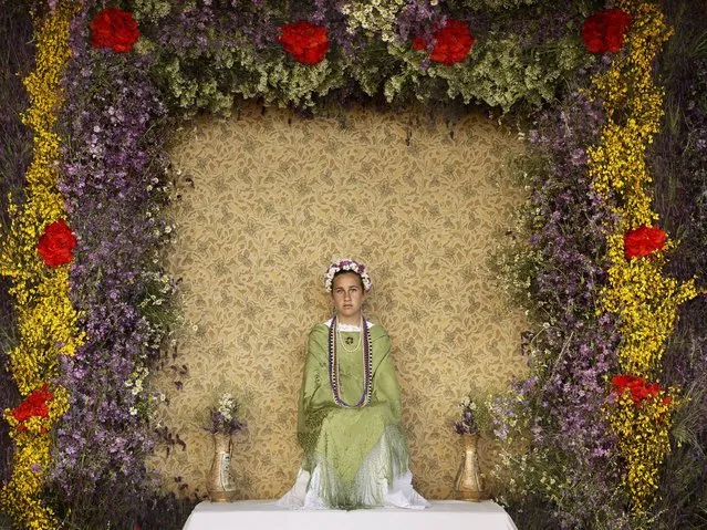 A “Maya” girl sits in an altar during the traditional celebration of “Las Mayas” on the streets in Colmenar Viejo, near Madrid, Spain, Friday, May 2, 2014. (Photo by Daniel Ochoa de Olza/AP Photo)