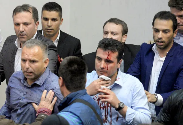 An injured leader of the Social Democrats Zoran Zaev is escorted out of the parliament in Skopje, Macedonia on Friday, April 28, 2017. Macedonia has been without a functioning government since 2015 when the country sank into political turmoil over a wiretapping scandal that brought down the ruling nationalist VMRO-DPMNE party bloc. Elections were held in December 2016 but no government has been formed yet. (Photo by Reuters/Stringer)
