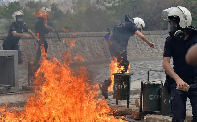 Riot police run away from the flames of a fire bomb thrown by protesters as they demonstrate to blame the ruling AK Party (AKP) government on the mining disaster in western Turkey, in Ankara May 14, 2014. (Photo by Reuters)