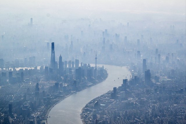 A general view of the city of Shanghai is seen from a passenger plane on February 12, 2024. (Photo by Hector Retamal/AFP Photo)