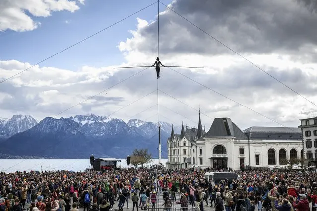 The tightrope walker of the Basinga Company, Tatiana-Mosio Bongonga, crosses the market square of Vevey, in Vevey, Switzerland, Saturday April 9, 2022, on a 180-metre long, 20 m high cable during the show “Ligne Ouverte”, on the occasion of the celebration of the link between the population and the performing arts organised by the Theatre le Reflet. (Photo by Gabriel Monnet/Keystone via AP Photo)