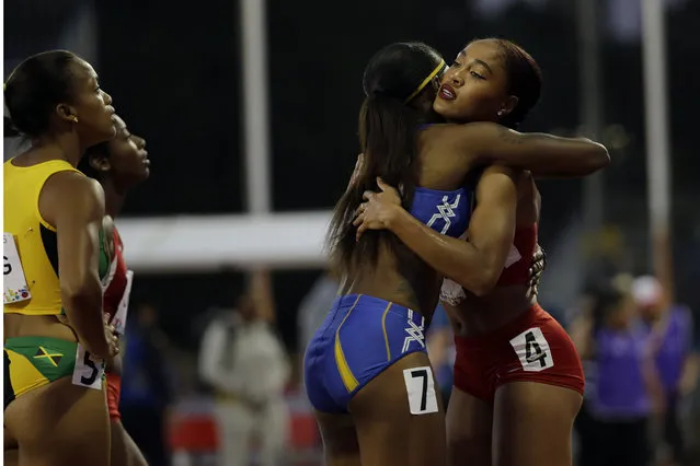 USA's Queen Harrison, right, is congratulated by another competitor after she won the women's 100 meter hurdles at the Pan Am Games in Toronto, Tuesday, July 21, 2015. (Photo by Mark Humphrey/AP Photo)